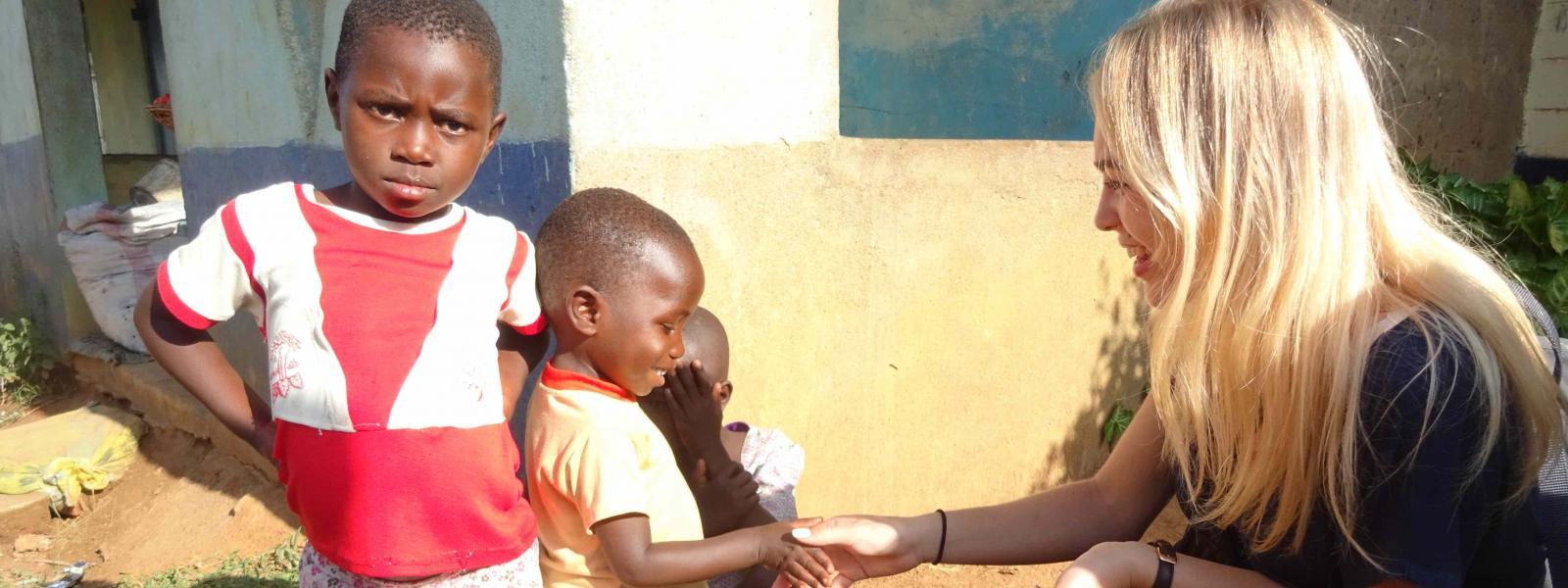 En elever fra Borupgaard snakker med to børn i Kenya